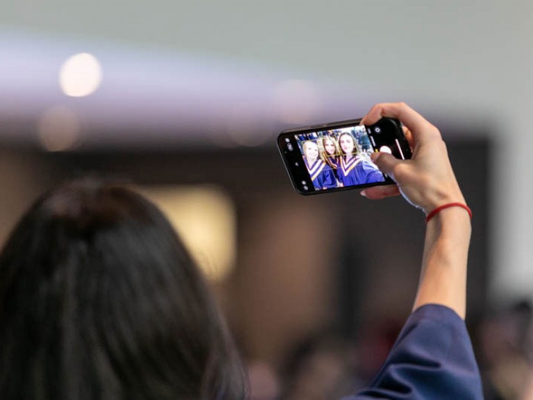 Close up of someone's phone screen as they take a selfie with their friends