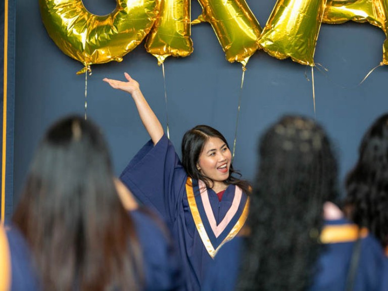 Graduate raises her arm in excitement