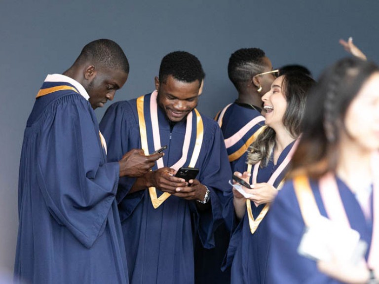 Graduates holding their cell phones