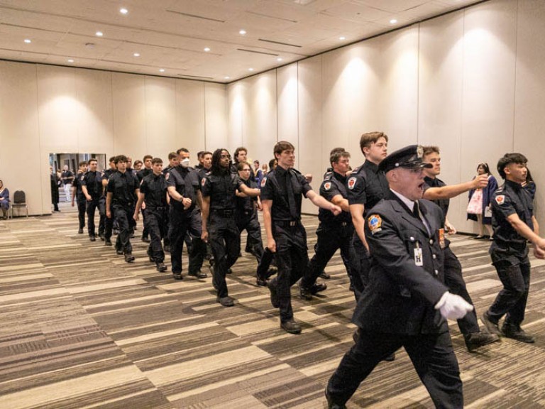 Police graduates walking behind their leader in three rows