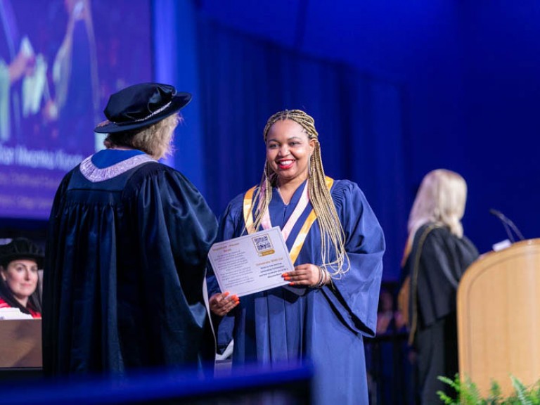 Graduate receives their certificate from Humber president