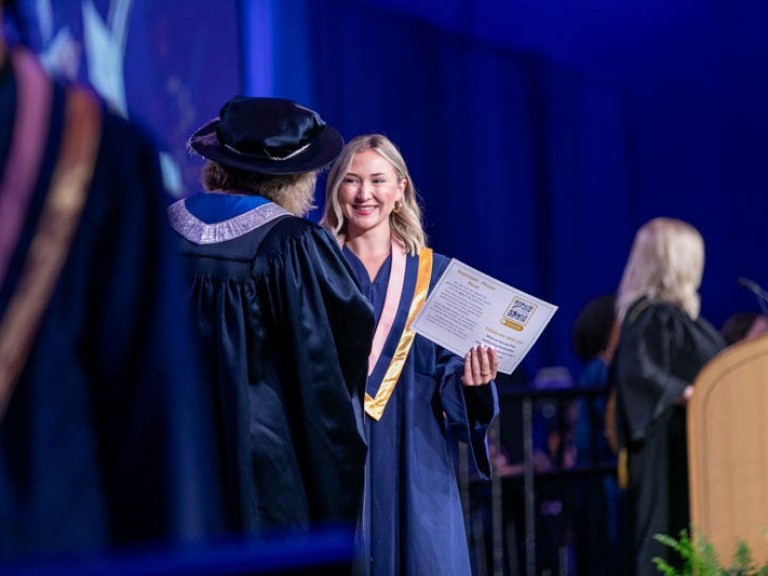 Smiling graduate on stage