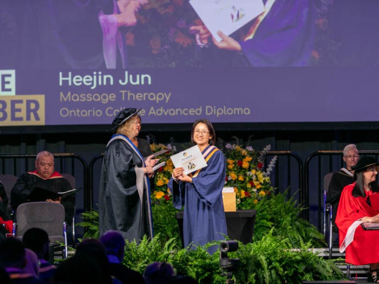 Massage therapy graduate Heejin Jun on stage