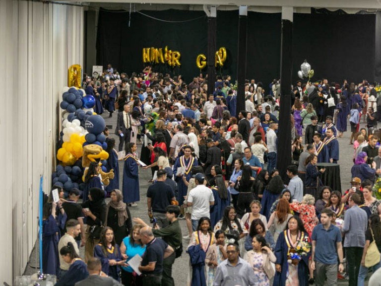 High angle photo of graduates and guests mingling in the reception area