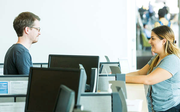 guy and girl talking at desk