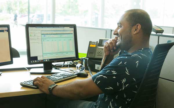 male sitting at a computer on the phone