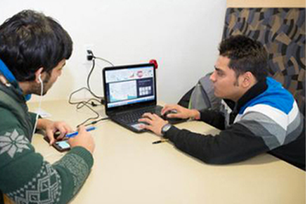 two students working on laptops