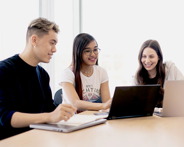 Three students working together at table