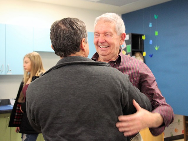 two persons greeting each other with a smile