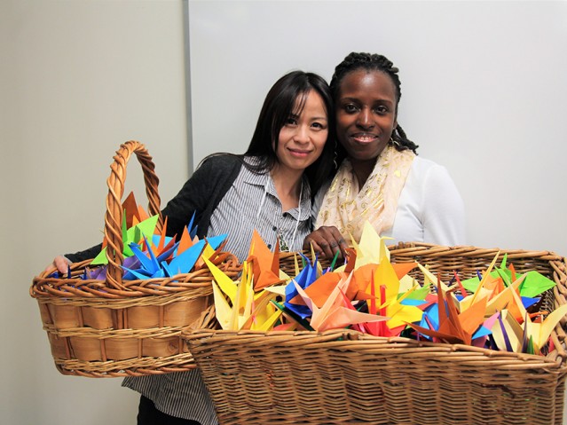 Two women holding baskets full of paper toys