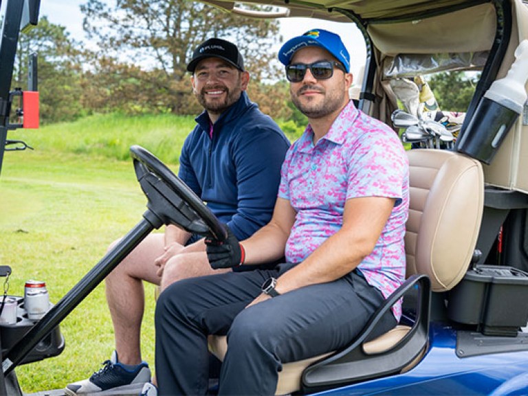 two people posing on a golf cart
