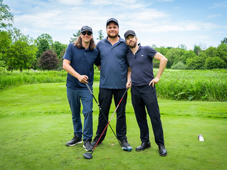 three people posing on the golf course