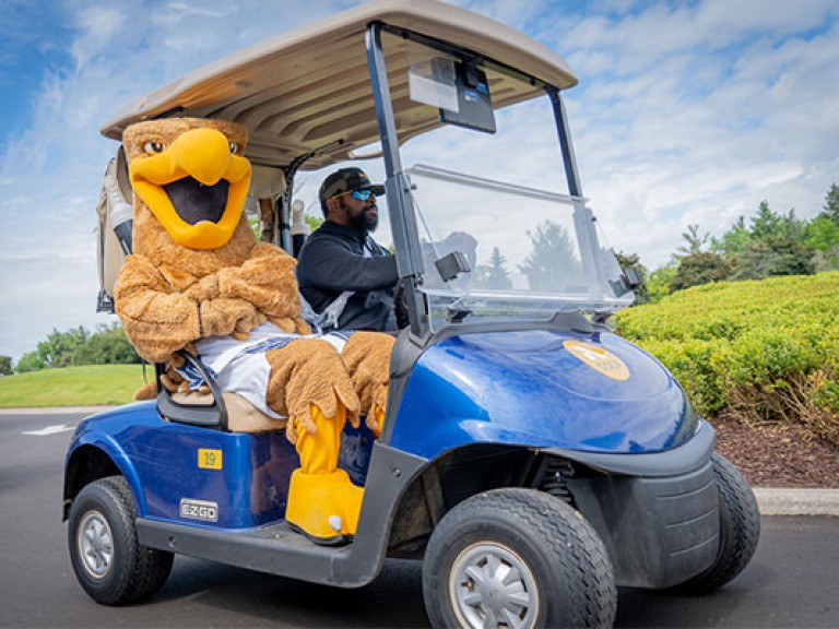 Howie the Hawk sitting on a golf cart