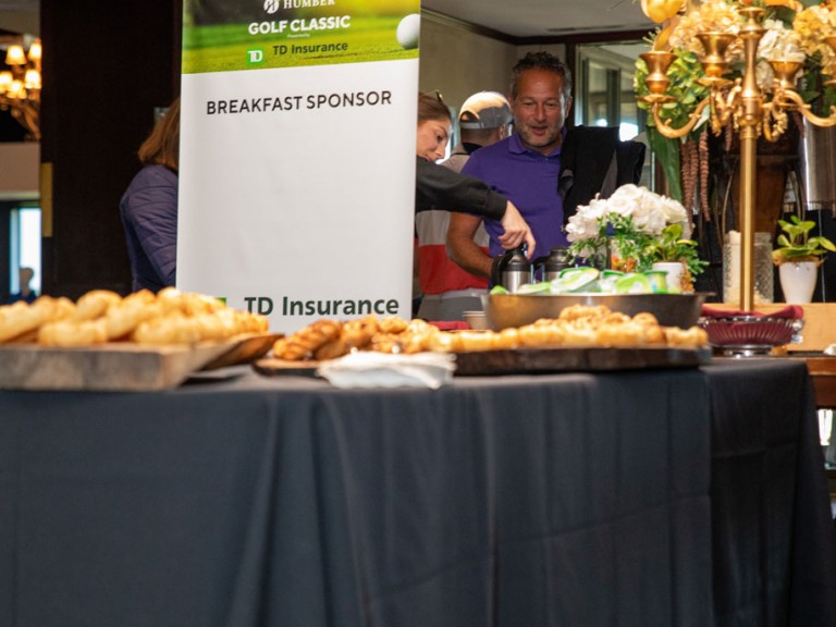 People gathered near table of food