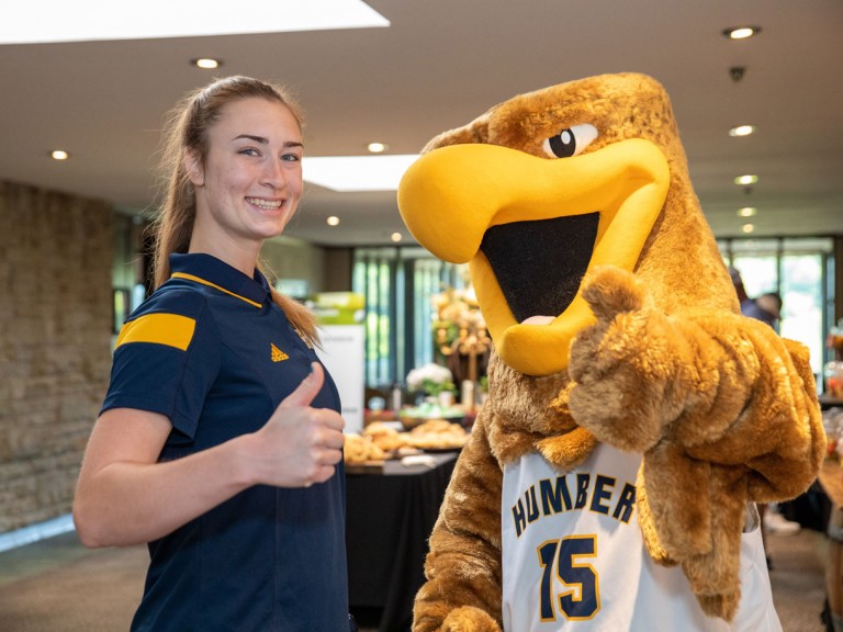 Mascot and person holding thumbs up
