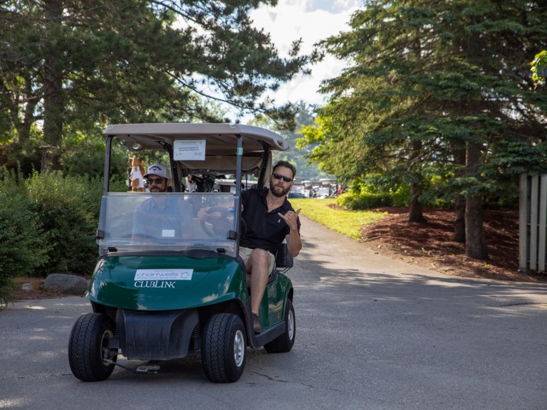 Golf cart driver leans out of cart