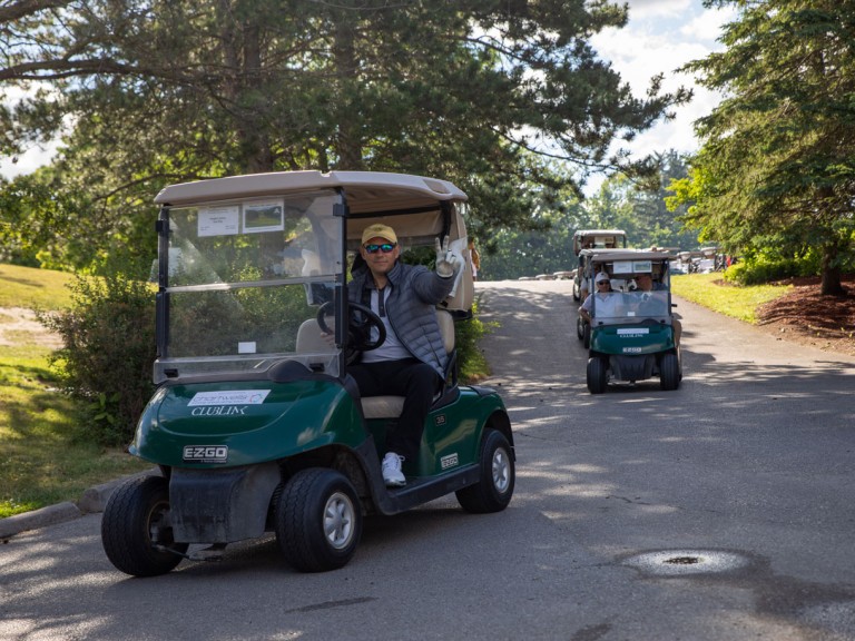 Golf cart driver holds up peace sign