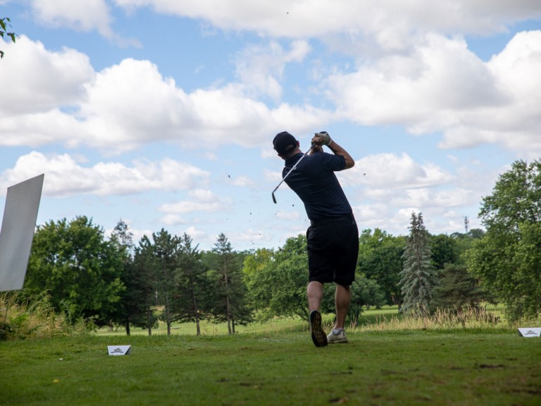 Person with golf club over their shoulder after swinging