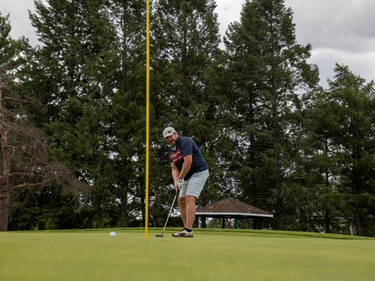 Person aiming towards flag post