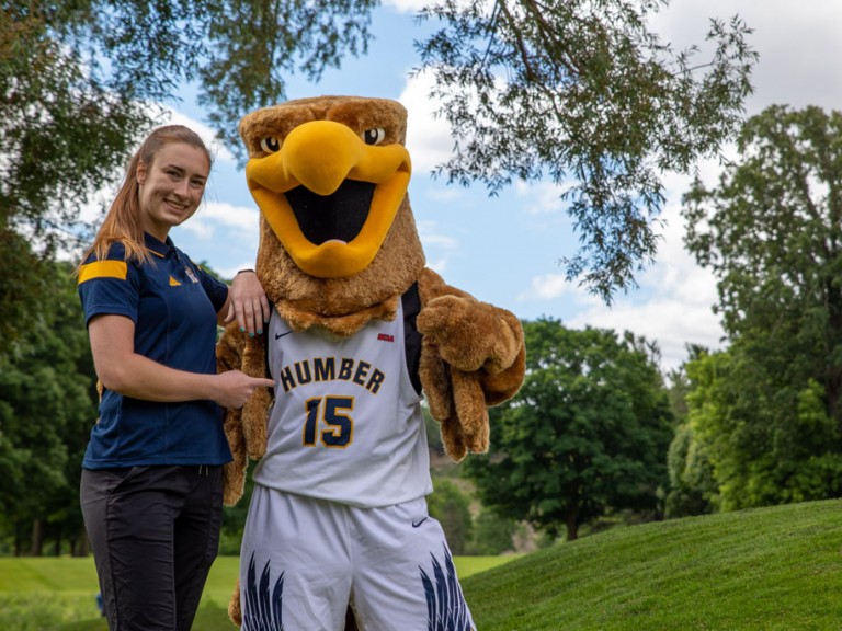 Person points to Humber mascot's jersey