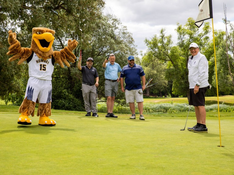 Humber mascot celebrates with golfers on course