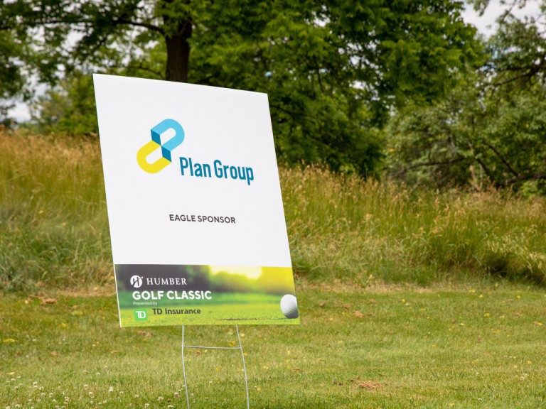 Banner on golf course that reads: Plan group Eagle sponsor