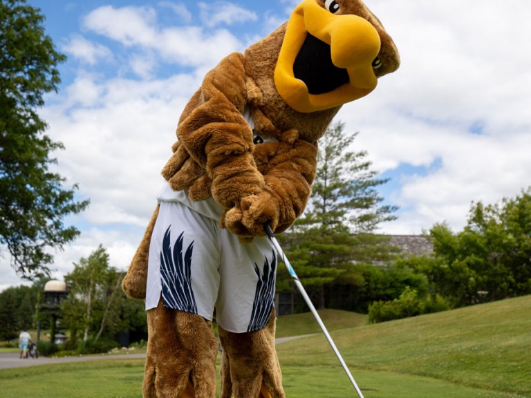 Humber mascot looking at camera with club