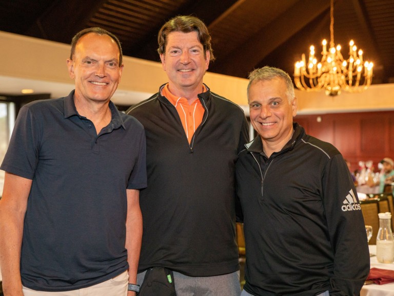 Two people posing with former Humber president Chris Whitaker