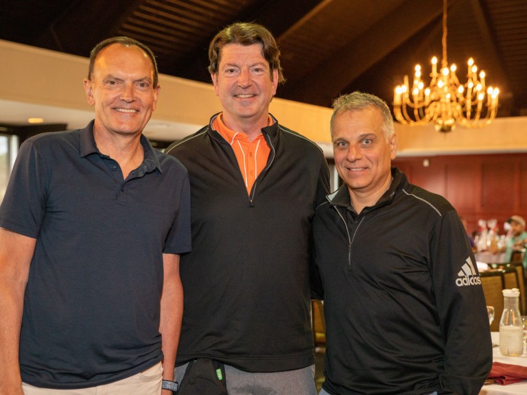 Two people posing with former Humber president Chris Whitaker
