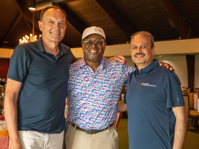 Christ Whitaker next to two people for photo