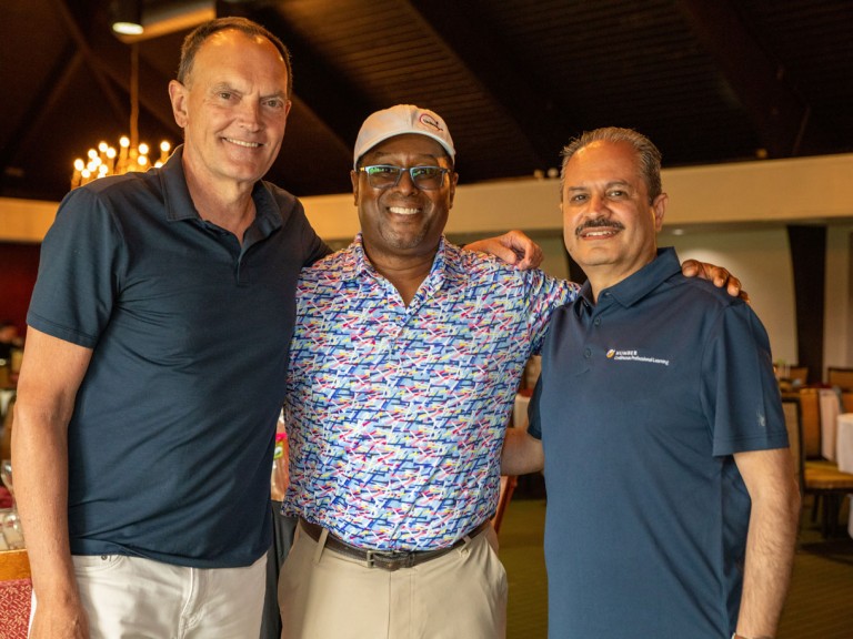 Christ Whitaker next to two people for photo