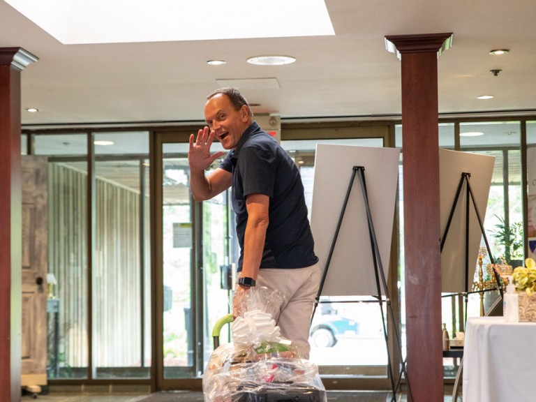 Chris Whitaker waves towards camera with trolley