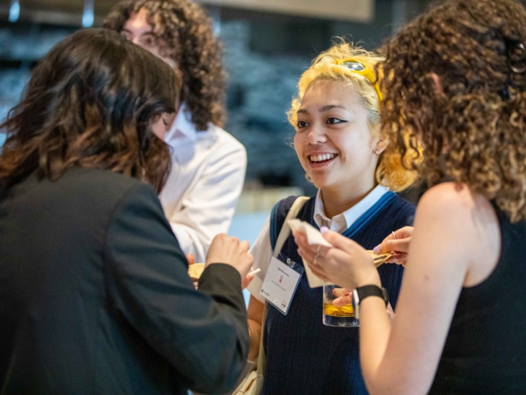 Person smiling as they talk to others at reception