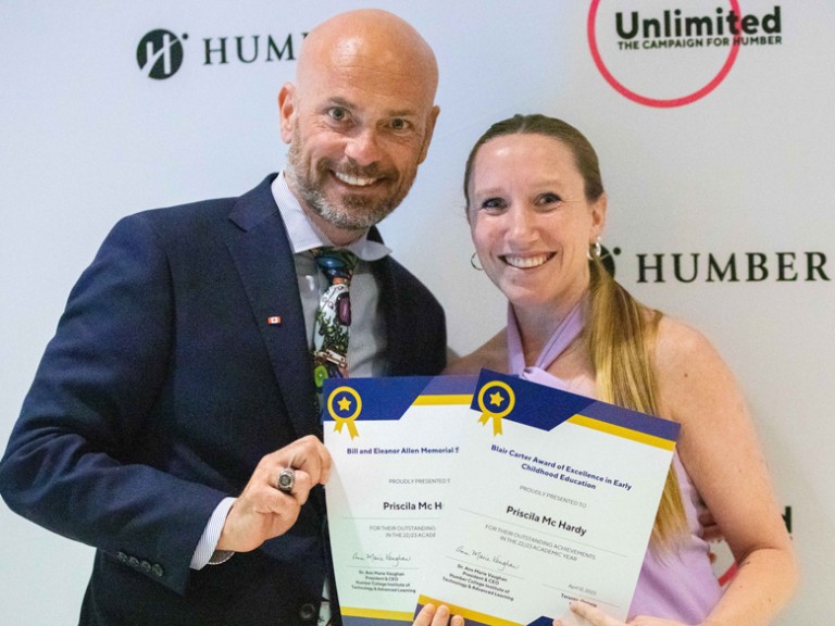 Two people posing with awards