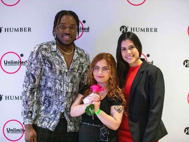 Three people pose for camera