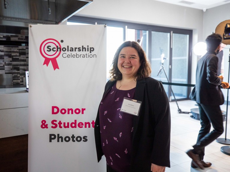 Person posing next to banner that reads: Scholarship celebration, Student and Donor photos