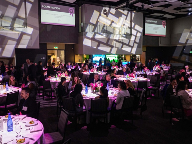 Event room with people seated at round dinner tables