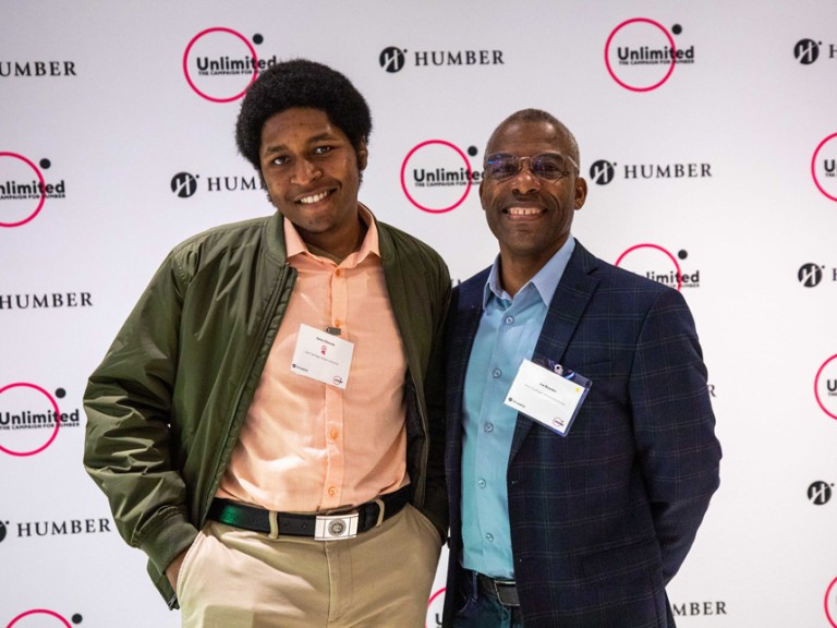 Two people posing for photo in front of Humber Unlimited backdrop