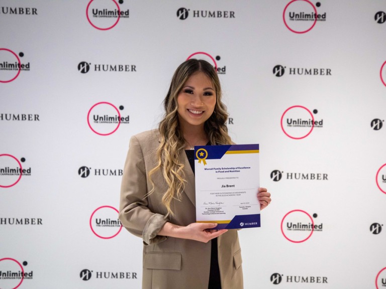 Person holding award and smiling