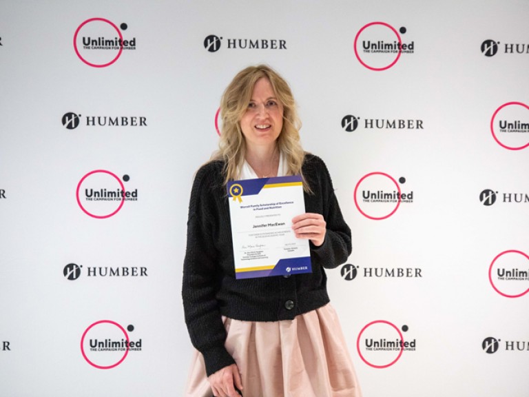 Person holding award in front of Humber Unlimited backdrop wall