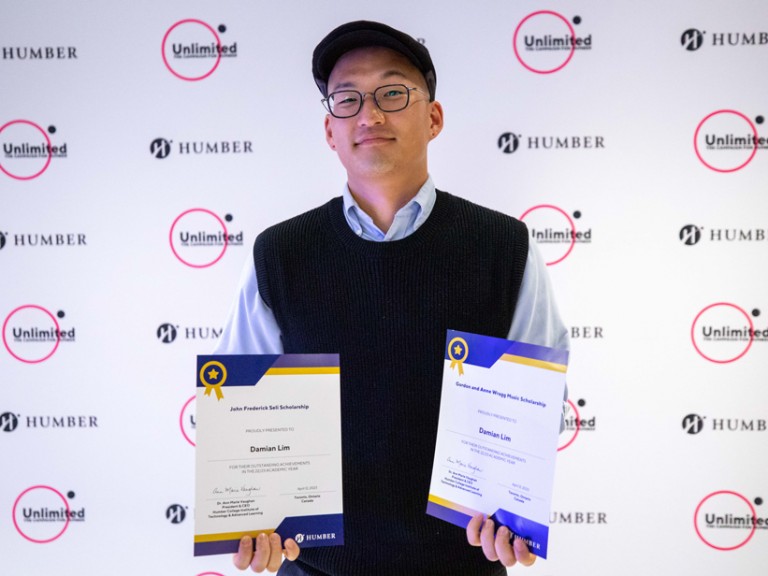 Person holding two awards