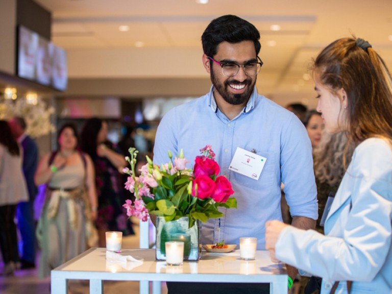 Two people talking at table during event reception