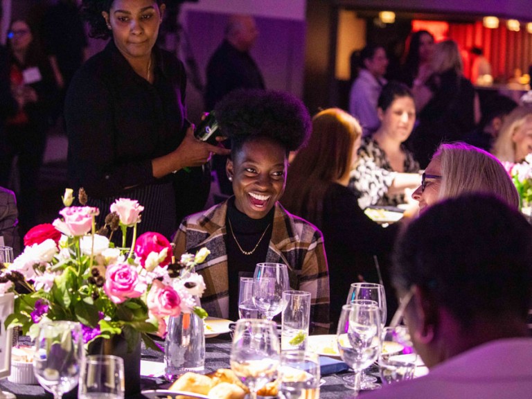 Person sitting at dining table smiling at someone