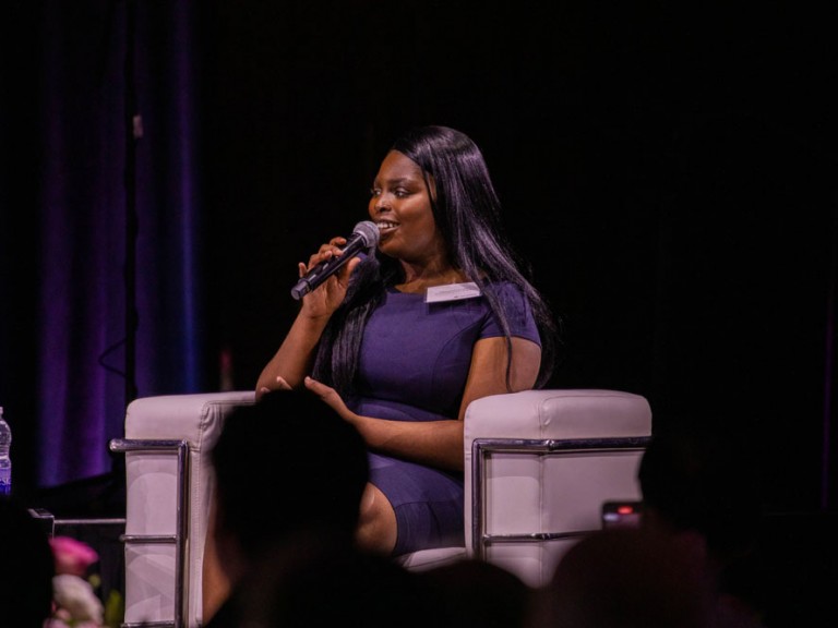 Person on stage speaking into microphone