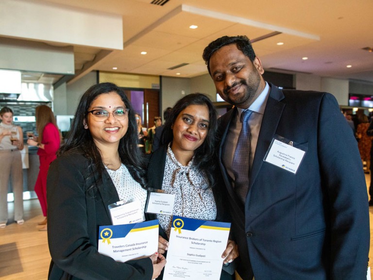 Three scholarship recipients smile for photo