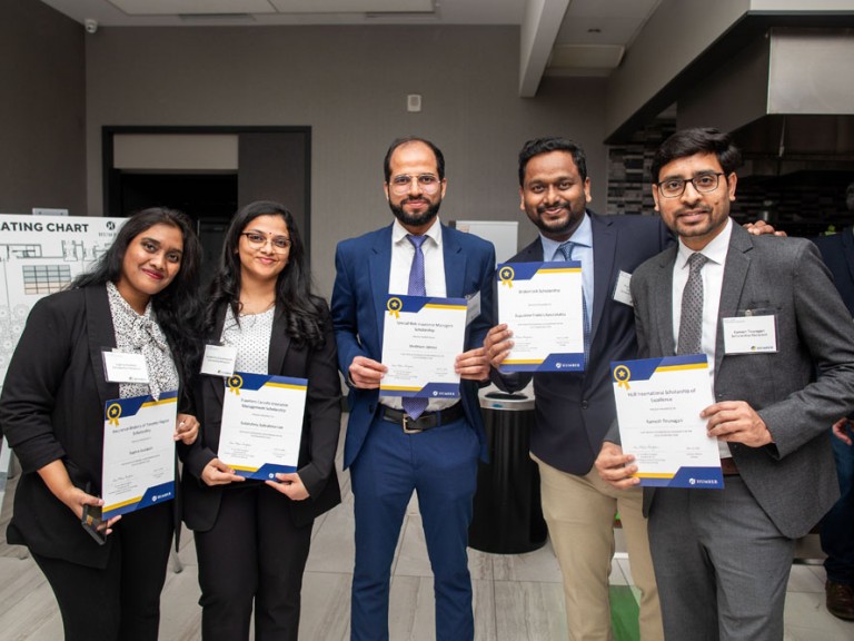 Five scholarship recipients pose with their scholarship certificates