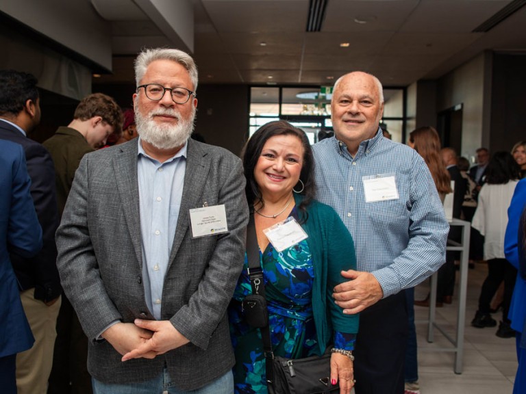 Three people pose for photo in event hall