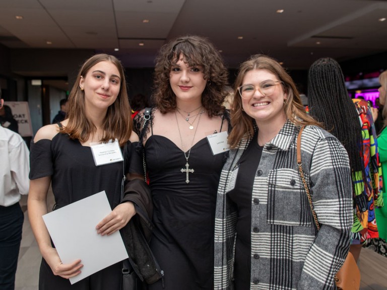 Three people pose for camera