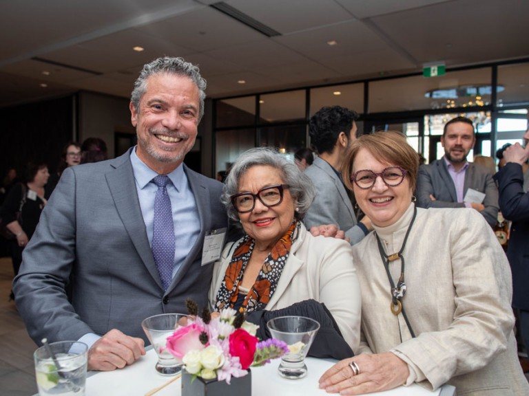 Three people smile for camera