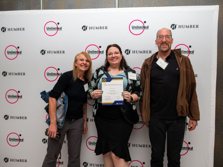 Three people pose for photo in front of Humber Unlimited backdrop